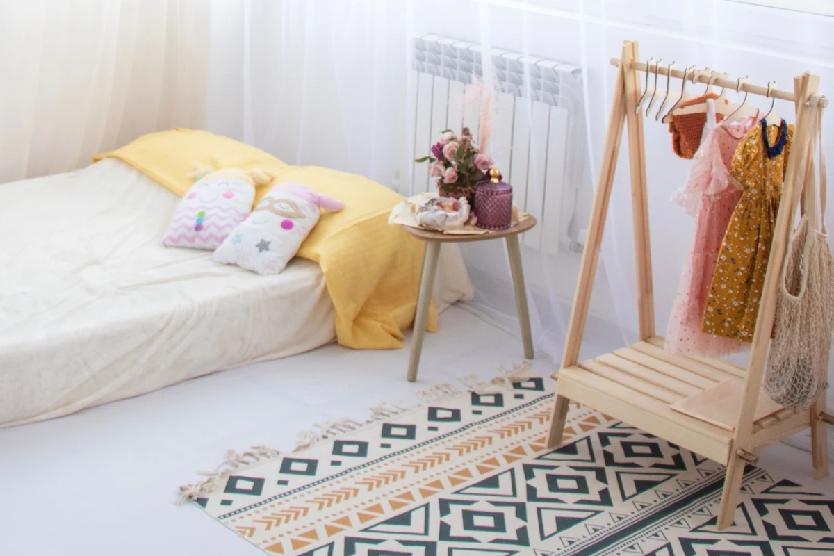 Dormitorio infantil con cama baja a ras de suelo y percha infantil accesible