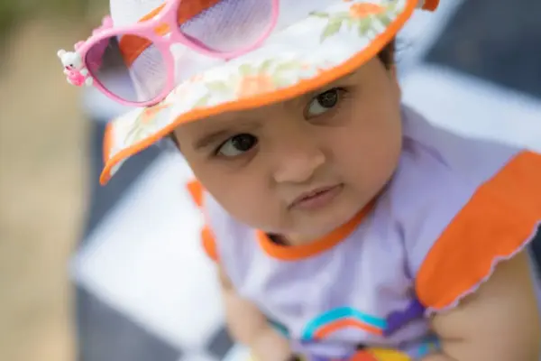 Bebé con gorro de sol y gafas de sol infantiles en verano