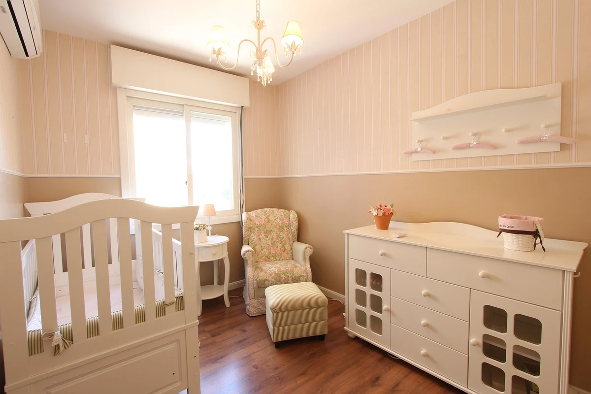 Habitación infantil ordenada con la cuna preparada y luz natural de día