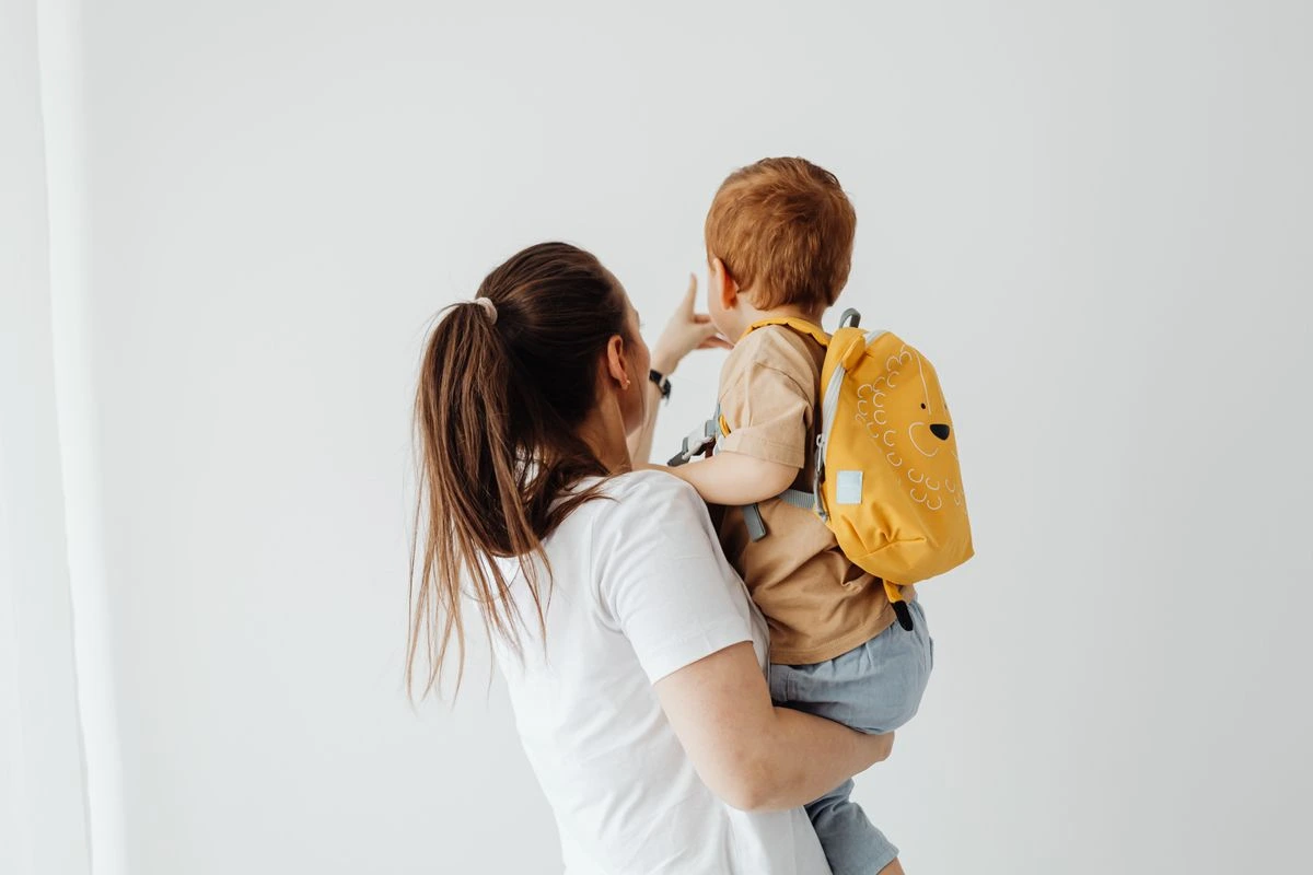 Niño pequeño con mochila listo para ir a la guardería