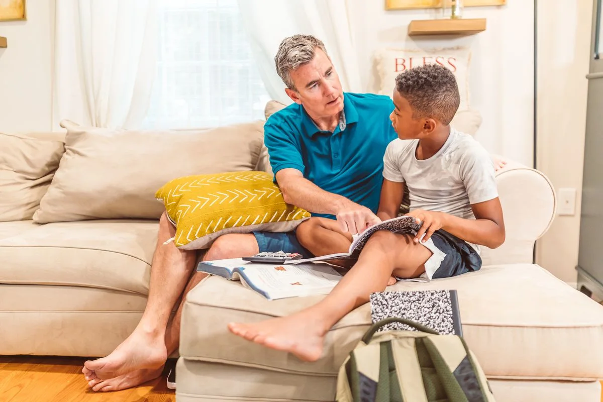 Padre e hijo sentados en el sofá conversando con tranquilidad