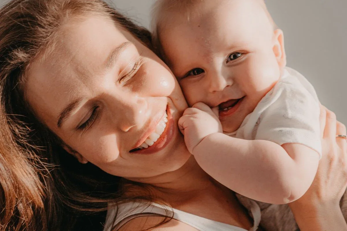 Madre y bebé se abrazan felices, mejilla con mejilla