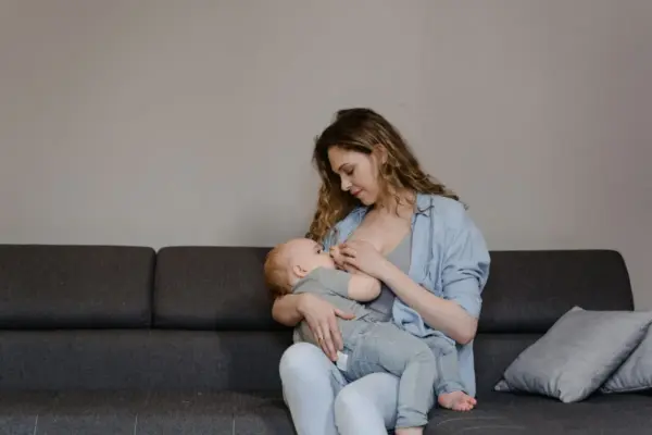 Madre sentada amamantando a su bebé en un asiento cómodo